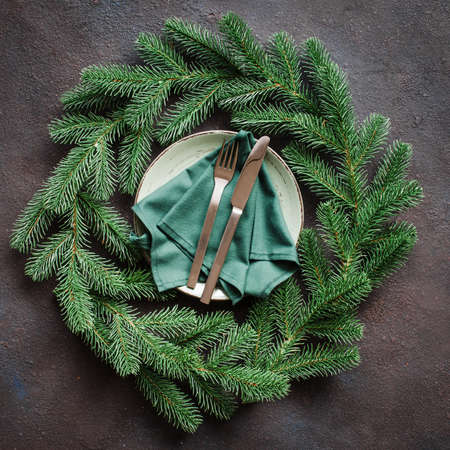 Festive table setting with xmas decorations in the form of a Christmas wreath. Christmas background in rustic stile. Winter table set for christmas or new year dinner.の写真素材