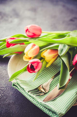 Festive Table Setting With Tulips. Holiday Table Set for Birthday, Mother's Day or for another holiday. Selective Focus. Toned imageの写真素材