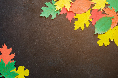Paper craft, red and yellow Autumn leaves.Top view on flat lay on dark concrete background. Space...