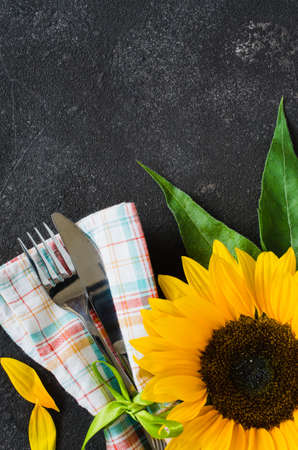Autumn table place setting, cutlery with napkin and sunflower. Thanksgiving dinner decorations. Copy space.の写真素材