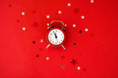 Festive Christmas background with alarm clock on red background in minimal style. New Year countdown. Template greeting card text designの写真素材
