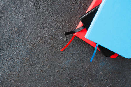 Stack of colorful notebooks for writing or books on dark background.の写真素材