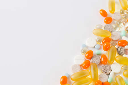 Assorted colorful tablets, pills, drugs isolated on white background. Medication and healthcare concept. Close up, copy space, selective focus.の写真素材