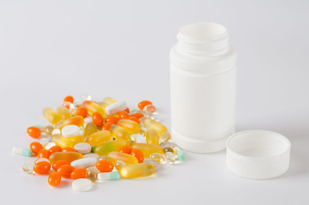 Assorted colorful tablets, pills, drugs isolated on white background. Bottle with pills. Medication...