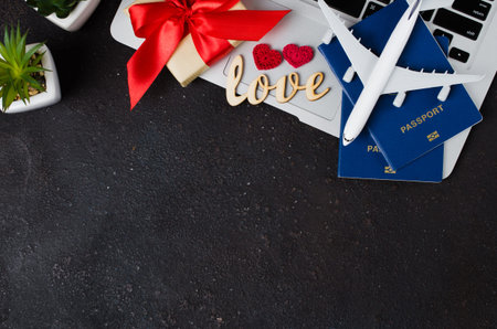 Planning a love trip or honeymoon. Gift Travel Concept. Airplane model, laptop, passports and gift...