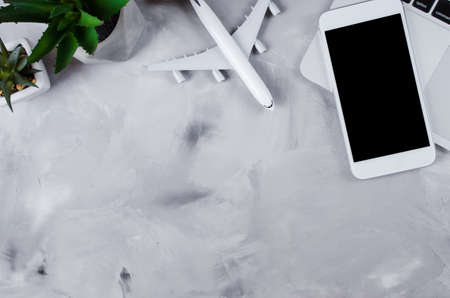 Travel booking concept. Laptop, passports, smartphone and airplane model on gray concrete. Top view or flat lay. Copy Space. Mock upの写真素材