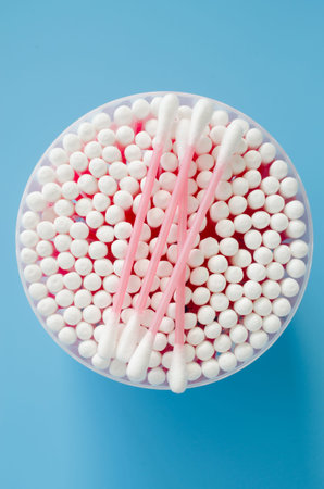 Cosmetic cotton buds on blue background. Sticks for cleaning ears. Top view.