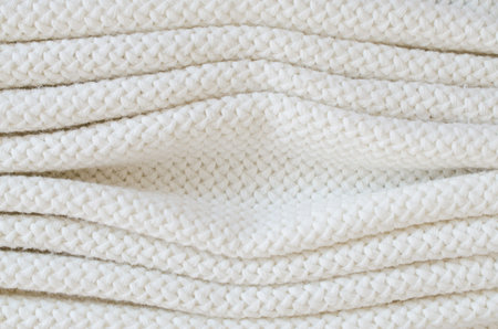 Beige knitted woolen background. Knitwear fabric texture. Scandinavian minimalism backdrop with copy...