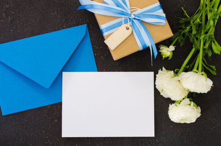 Blue envelope with blank white paper and present or gift box. Greeting card for Father's or...