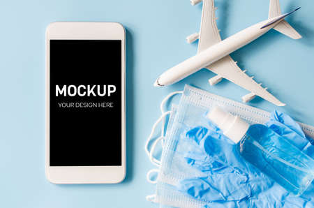Travel and Tourism Planning after Quarantine. Mock up of smartphone with airplane model, face mask and sanitizer.の写真素材