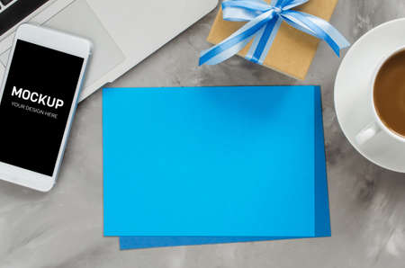 Greeting card with laptop computer, smartphone screen mock up, gift box and morning coffee. Father's day or birthday concept. Top view, space for text.の写真素材