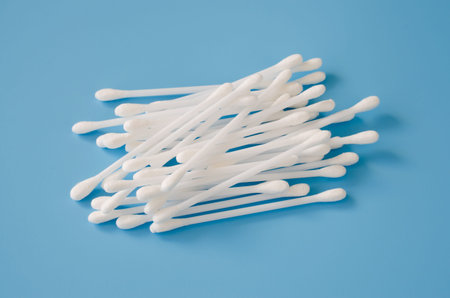 Cosmetic cotton buds on blue background. Sticks for cleaning ears.