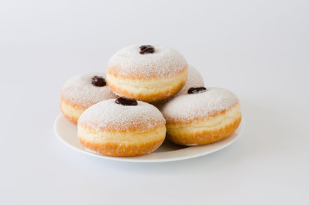Traditional sweet donuts with powdered sugar and jam. Fat Thursday or Hanukkah celebration.