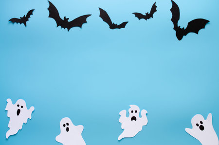 Happy Halloween holiday background with craft paper in the form of ghosts and bats.