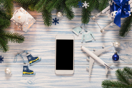 Christmas or New Year travel planning. Mockup blank screen smartphone with plane model for holiday...