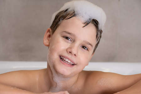 Portrait of Happy boy in bathroom Child bathes with lather on his headの写真素材