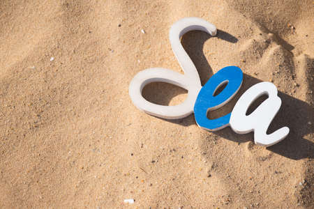 Decorative Sea inscription, woodenl letters against the backdrop of beach sand Summer vacation conceptの写真素材