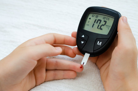 Diabetes concept - child finger with blood drop to checking blood sugar level