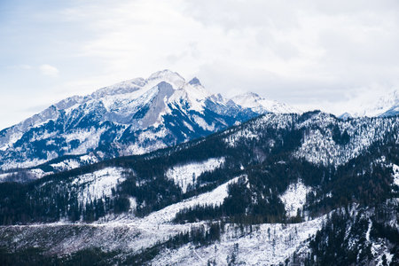 Scenic of snow-capped mountain landscape on a cloudy day in winter, Tatra Mountains.の写真素材