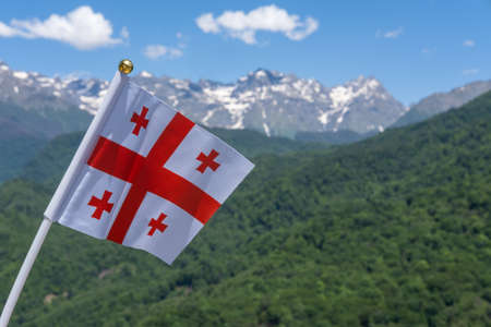 Georgia Flag Waving on Background of Mountains and Blue Sky.の写真素材