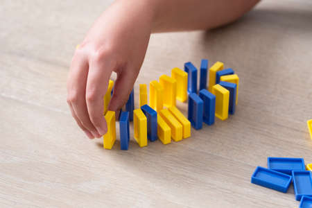 Child neatly lines up colorful domino blocks on the floor.の写真素材
