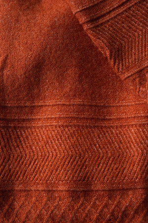Texture of an autumn knitted sweater with pattern. Autumn cozy background.