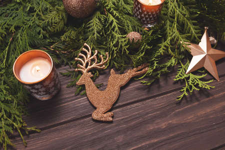 Christmas composition in brown. Fir branches candle and decorations on wooden table.の写真素材