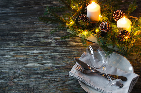 Christmas table setting with candles and fir branches