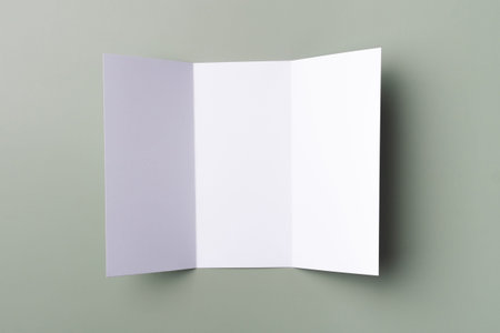 Mockup of white trifold brochure on a pale green background. Paper empty blank.