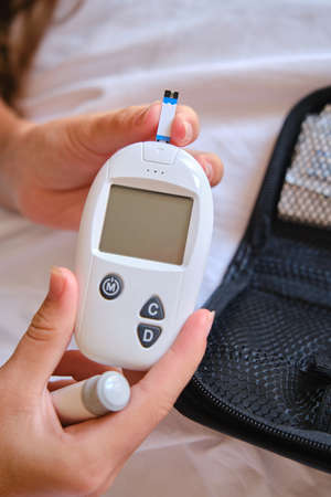Close-up of a blank screen of a glucometer in childrens hands.の写真素材