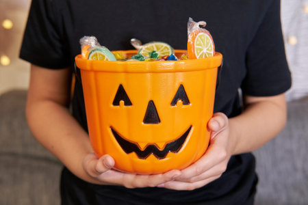 A boy in skeleton makeup pulls out candy from a Halloween party.