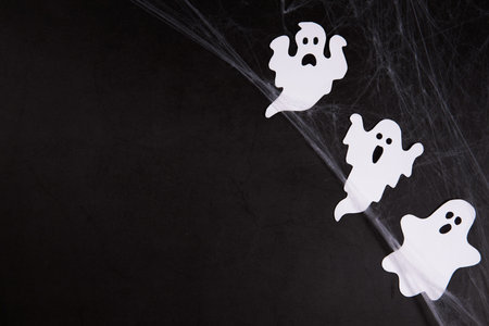 Spider web with ghosts on black background