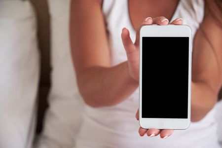 Smartphone with a blank screen in a womans hand. Template for Design.の写真素材