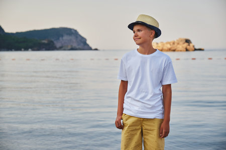 Portrait of a stylish teenage boy on the seashore. The concept of summer vacation and travel.の写真素材