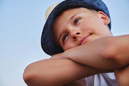 Portrait of a boy in a stylish hat against the sky. The concept of summer vacation and travel.の写真素材