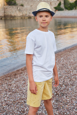 Portrait of a stylish teenage boy on the seashore. The concept of summer vacation and travel.の写真素材