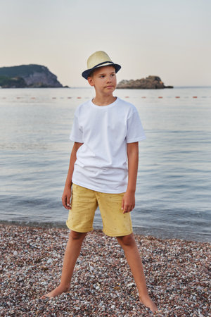 Portrait of a stylish teenage boy on the seashore. The concept of summer vacation and travel.の写真素材