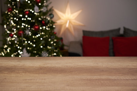 Table top with blurred living room background with Christmas tree and decorations.の写真素材