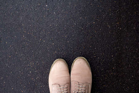 brown shoes on wet pavement, top viewの写真素材