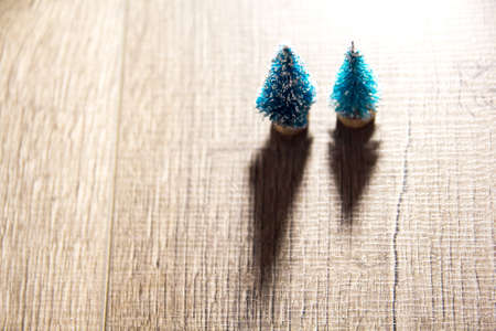 two Christmas trees on the background of bright Christmas gifts, bright colored lights, place under the text as substrateの写真素材