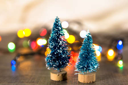 two Christmas trees on the background of bright Christmas gifts, bright colored lights, place under the text as substrateの写真素材