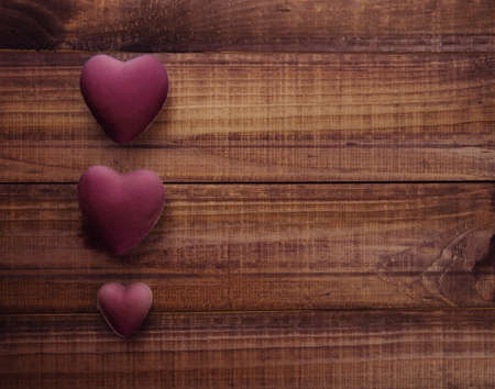 three white hearts on dark wooden background, concept of Valentines day as a symbol of loveの写真素材