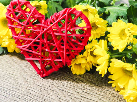 red heart and yellow flowers the concept of Valentines day, gift, love, space, on wooden backgroundの写真素材