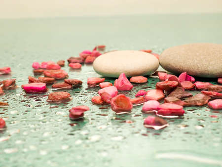 massage stones, pebbles on a green background with drops of water lined with rows as the concept of Spa treatment and restの写真素材