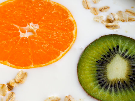 orange Mandarin kiwi closeup in the curd, cream background, coverの写真素材