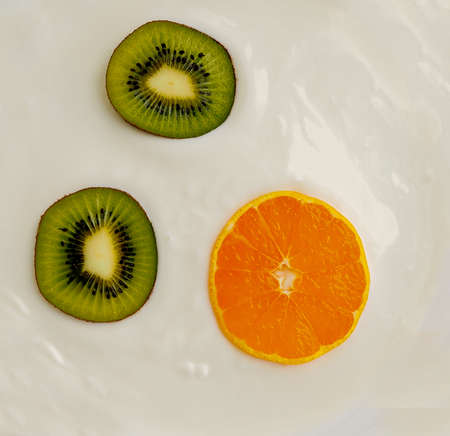 orange tangerine and kiwi closeup of white cream with a texture as a background, substrate, coverの写真素材