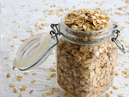 Rolled in a glass jar, spilled cereal, the concept of healthy food, space for textの写真素材