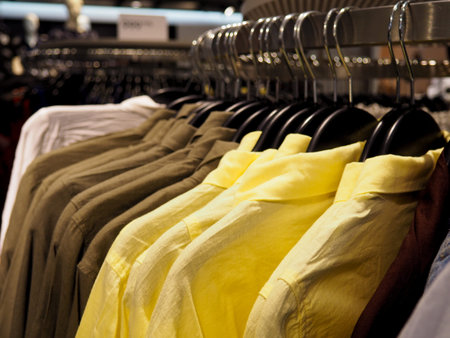Choice of fashion clothes of different colors on wooden hangers