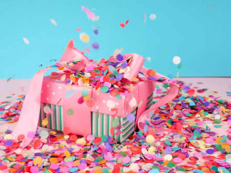 gift box and flying confetti, holiday atmosphere, on a blue and pink backgroundの写真素材