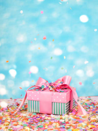 gift box and flying confetti, holiday atmosphere, on a blue and pink backgroundの写真素材